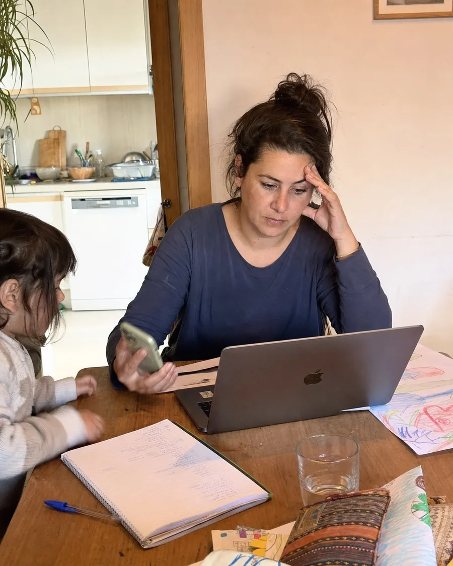 Mujer gestionando el trabajo y la carga familiar desde la mesa de casa