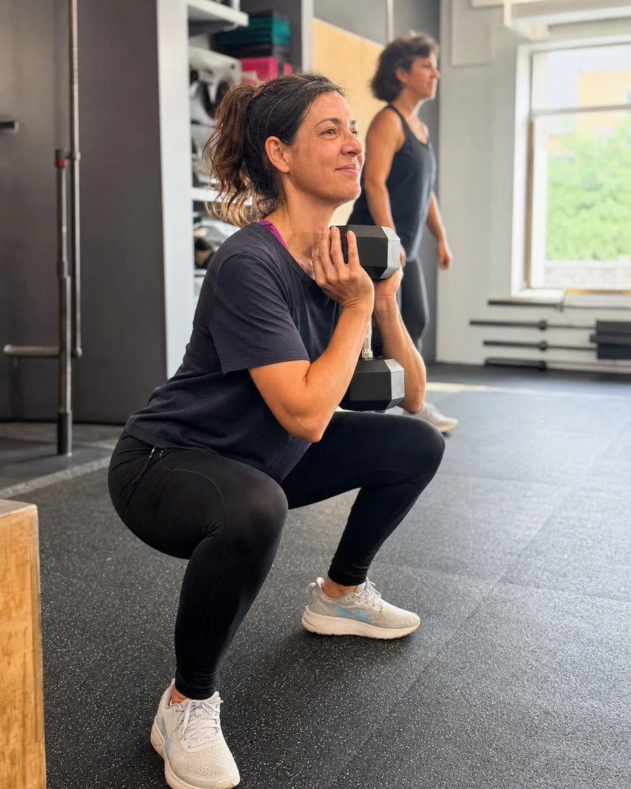 Mujer de más de 40 años entrenando fuerza acompañada